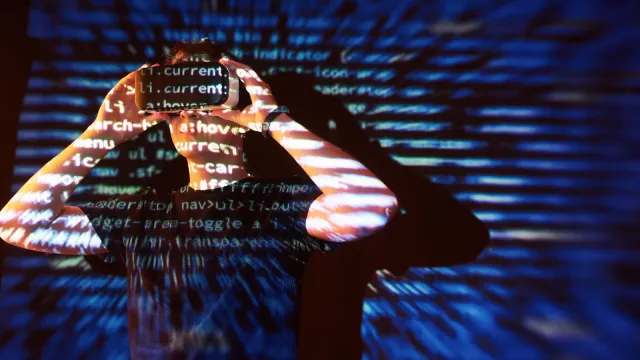 double-exposure-caucasian-man-virtual-reality-vr-headset-is-presumably-gamer-hacker-cracking-code-into-secure-network-server-with-lines-code-10139135.webp